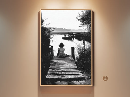 A black and white art print shows a girl on a pier. This vintage coastal childhood art evokes nostalgia. Perfect as beach house decor. The artwork creates a calm space in any room. A thoughtful gift for lovers of seaside photography.