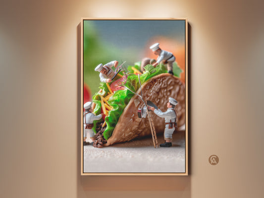 Framed artwork of miniature chefs constructing a taco. This food art features a unique perspective. The chefs add lettuce tomatoes and cheese to the taco. It's a playful and creative food photography piece. Perfect for kitchen or dining room wall art.