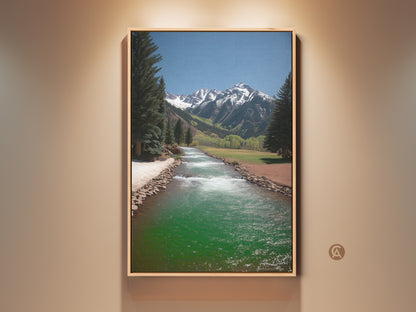 Rustic mountain river landscape canvas art is framed in natural wood. Turquoise blue green river creates a tranquil scene. Snow capped mountains rise above pine trees. Perfect wall art for nature and outdoor lovers.