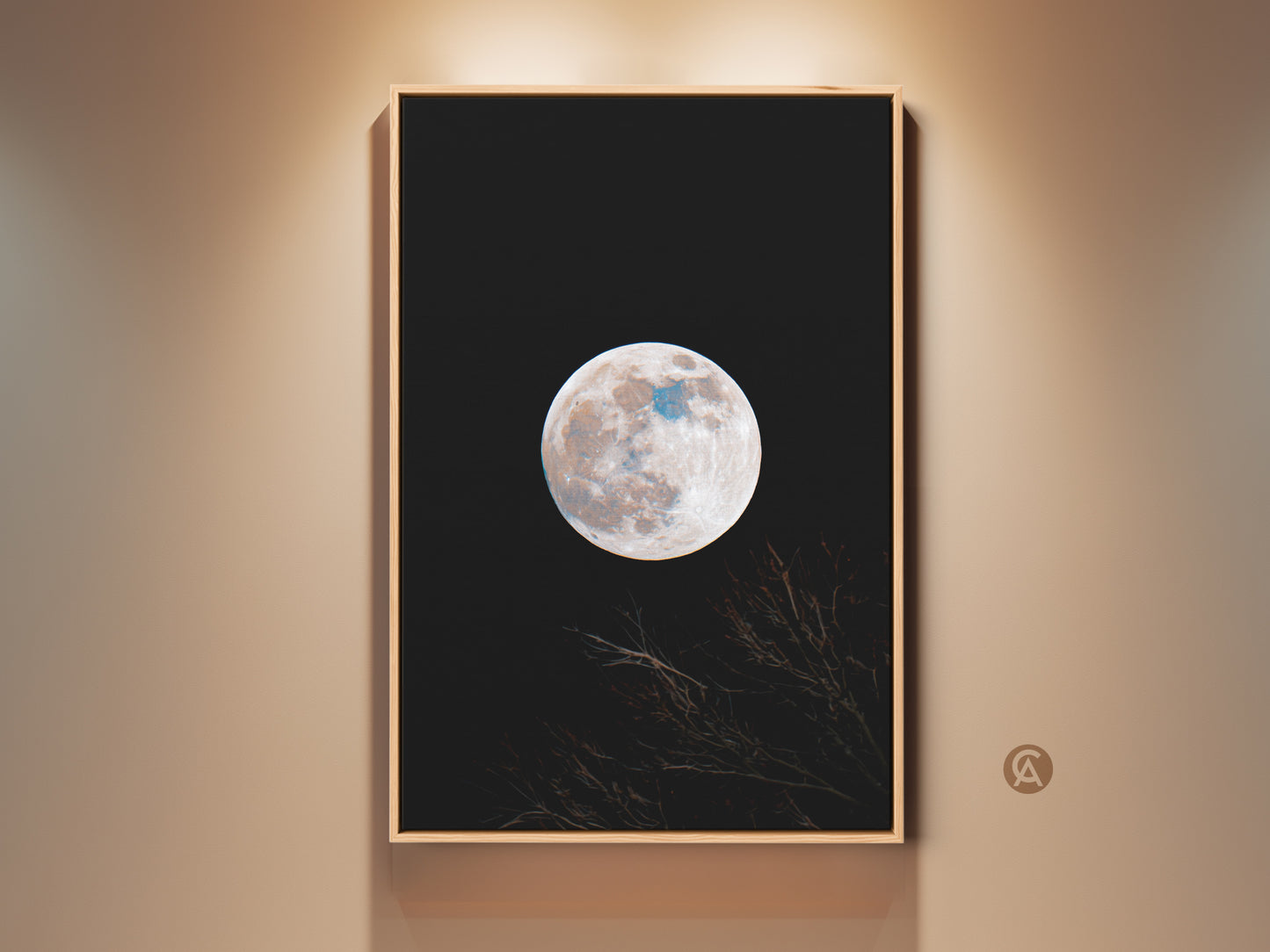 Framed moon art print. This wall art features a full moon against a black sky. Branches are silhouetted at the bottom. The artwork is displayed in a natural wood frame. Shop framed moon art for your home.