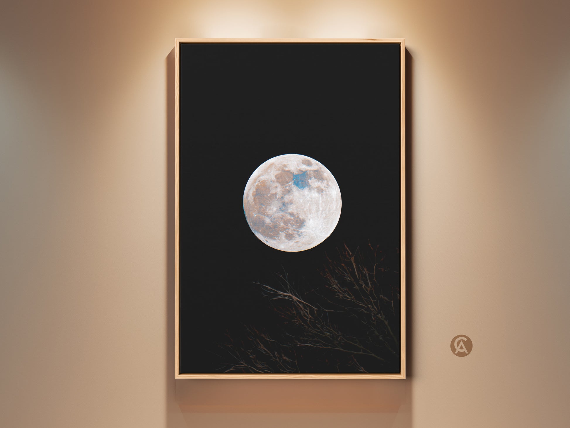 Framed moon art print. This wall art features a full moon against a black sky. Branches are silhouetted at the bottom. The artwork is displayed in a natural wood frame. Shop framed moon art for your home.