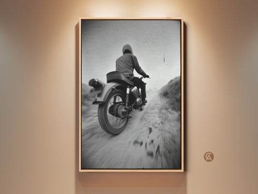 Framed monochrome motorcycle rider canvas print. Retro adventure wall art enhances this vintage biker gift. Perfect industrial office decor. The rider navigates a dirt road embodying freedom. Ready to hang art for motorcycle enthusiasts.