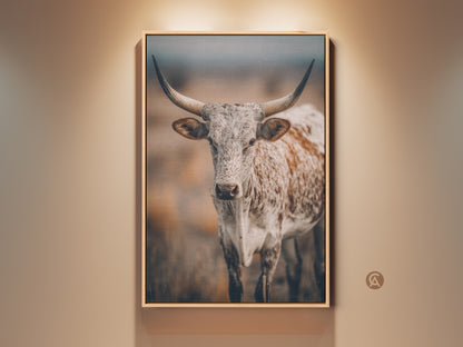 Close up of a Longhorn Cow Wall Art. This rustic farmhouse decor features a Texas wildlife canvas print. The neutral color palette complements any country entryway decor. It is a great gift for homeowners. The artwork brings a touch of the wild indoors.