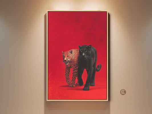 Framed wall art showcases a black panther and leopard against a red backdrop. The art is displayed in a natural wood frame under warm lighting. This striking piece adds a touch of wildlife elegance to any interior decor. The vibrant colors and detailed animal artwork create a captivating focal point for art lovers.