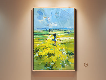 Framed Yellow Field Landscape Artwork. This boho canvas wall art features a girl walking in an impressionist nature scene. A perfect home decor gift with vibrant colors. Bring a touch of countryside charm to your space with this piece. It captures a dreamy landscape under a blue sky.