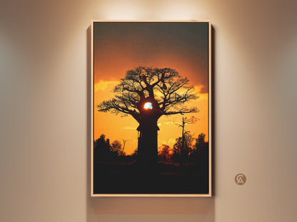 Silhouetted baobab tree canvas print against an orange and yellow African sunset. This eclectic home wall art brings warmth to any space. A unique housewarming gift for the traveler in your life. Perfect as landscape wall art for bedroom decor. Dark grey accents enhance this residential landscape art piece.