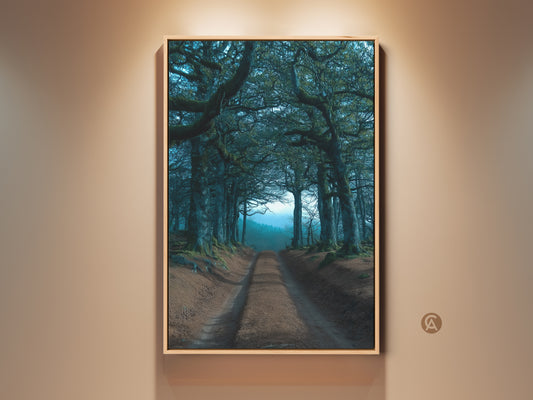 A framed art print displays a tree tunnel in emerald and teal hues. This dark academia landscape artwork adds a mystical touch to any room. Perfect for entry halls or living spaces this nature inspired piece is a unique wall decor choice.