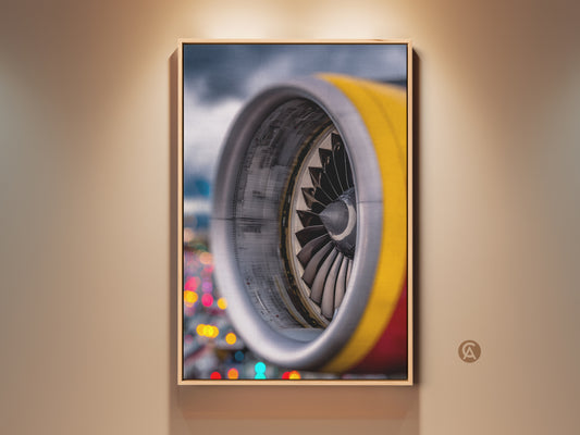 Industrial jet engine artwork is displayed in a wood frame. The aviation technology canvas features silver yellow and red abstract colors. This wall decor brings a loft-style aesthetic. It is a perfect office gift and a unique wall hanging.
