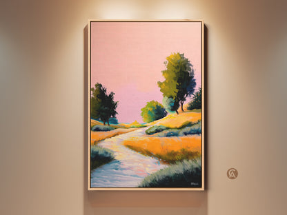 Framed pink yellow orange landscape canvas art is hung against a beige wall. The boho river trees print has an impressionistic style. This expressive nature wall decor makes a great bedroom art gift.