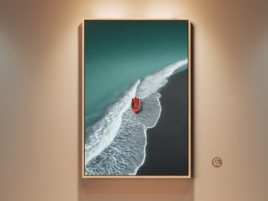 Framed minimalist beach artwork. Teal ocean meets a dark sand shore. A red boat adds a pop of color. This coastal canvas art is framed in oak. Perfect nautical home gift or housewarming art.