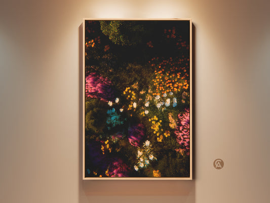 Framed floral artwork displayed on a neutral wall. This vibrant canvas art features a dark backdrop with colorful flowers. Buy floral canvas art to add a pop of color to any room. The artwork adds a touch of nature-inspired beauty to any space.