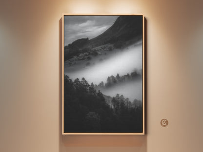 Framed black and white mountain art print. This monochrome landscape canvas wall art captures a foggy village scene. Contemporary nature scene decor makes a perfect housewarming gift. The black frame enhances the neutral wall art.