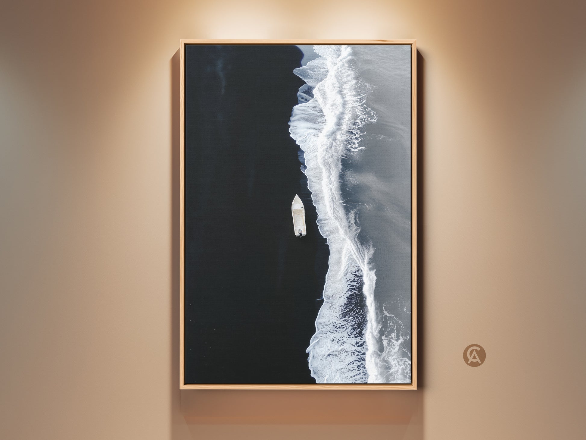 Black and white ocean canvas art in a wood frame hangs on a beige wall. The minimalist boat aerial view is a modern coastal beach wall decor. Perfect bedroom art print.
