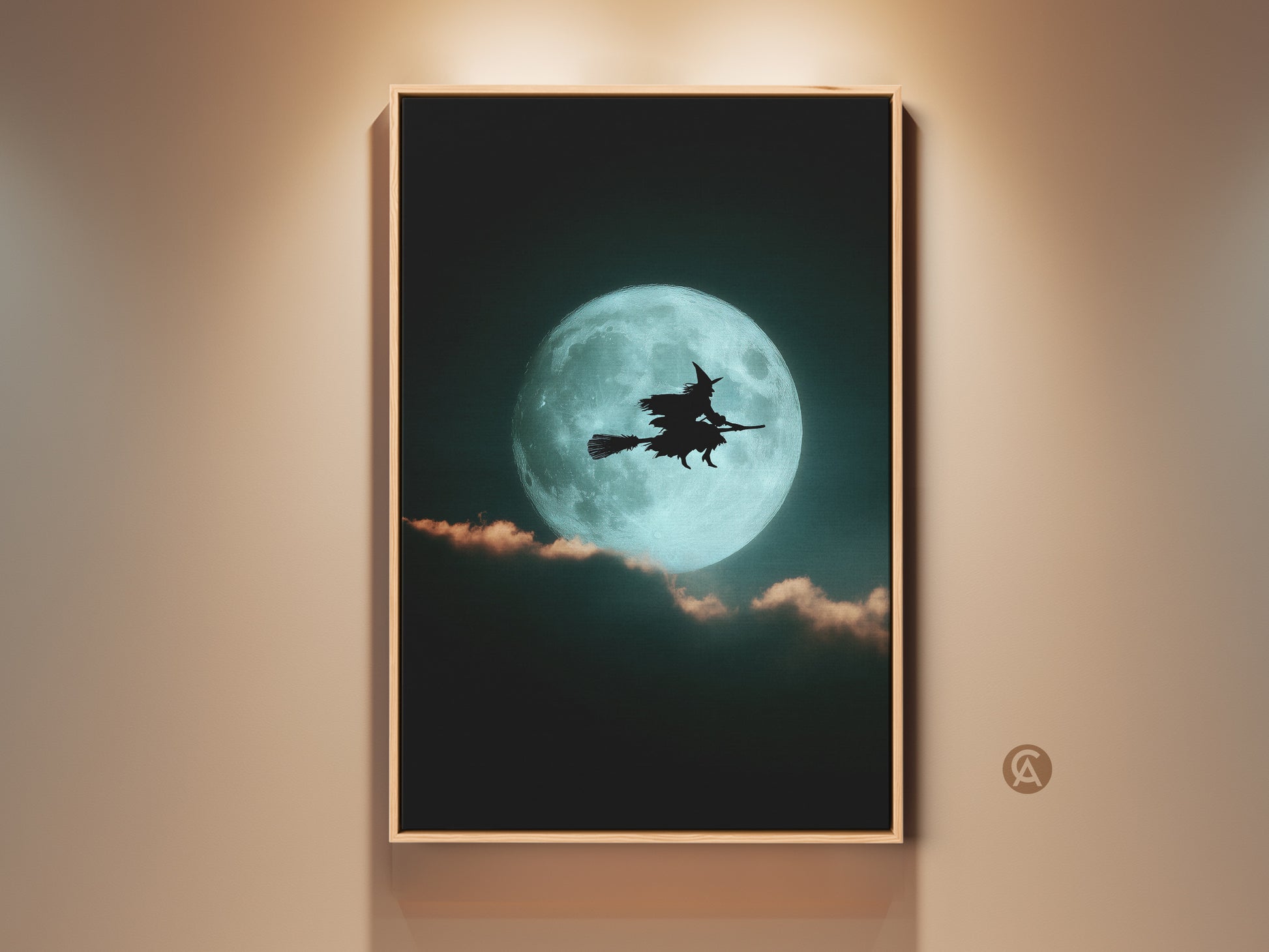 Framed teal moon witch canvas art hangs on a wall. The artwork features a witch silhouette against a bright teal moon. This gothic Halloween art is perfect eclectic bedroom decor or a witchy gift.