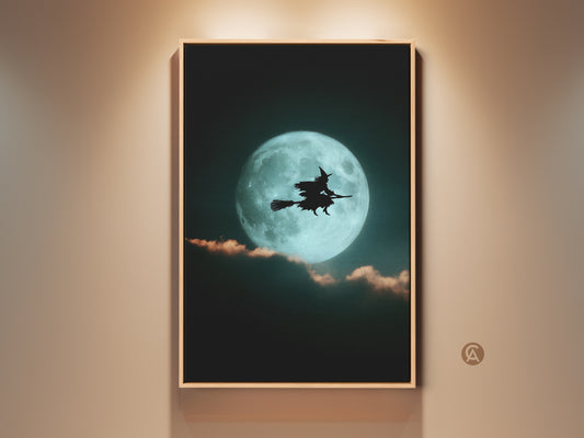 Framed teal moon witch canvas art hangs on a wall. The artwork features a witch silhouette against a bright teal moon. This gothic Halloween art is perfect eclectic bedroom decor or a witchy gift.
