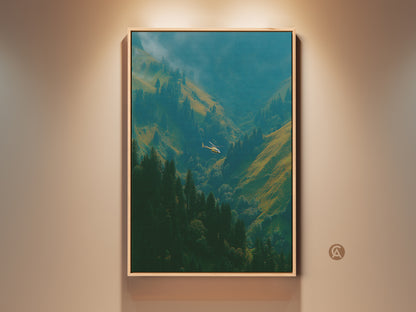 Framed artwork of a helicopter flying through a mountain valley. The art is displayed on a beige wall.  This fine art print would look great in any room. The frame is a light oak color. Add a piece of nature to your home.