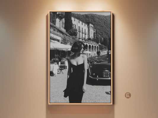 Monochrome canvas art print featuring a vintage woman in a black dress.  A retro car is parked nearby. This Mid-Century Modern wall decor creates a cinematic and sophisticated room decor. Perfect noir aesthetic gift for travel enthusiasts.  This vintage Italian landscape art will elevate any living space.