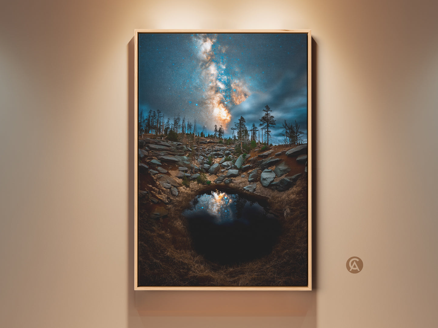 Framed space astrophotography canvas print. The Milky Way and rugged landscape are featured. A mountain pool reflects the night sky in teal and orange. Perfect cosmic wall art for home decor.