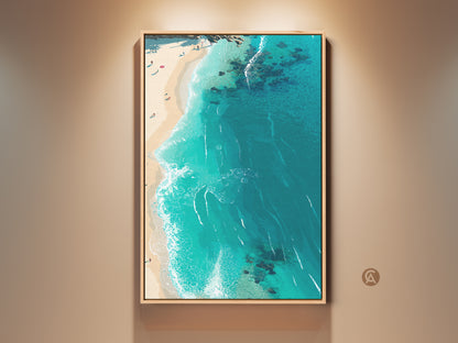 Framed beach wall art adds a coastal touch. The aerial view captures the stunning turquoise ocean and sandy shore. The artwork is framed in a natural wood finish ready to hang. Perfect for bringing a serene beach vibe to any room.