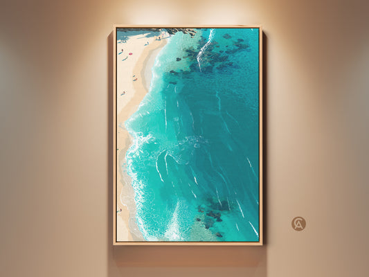 Framed beach wall art adds a coastal touch. The aerial view captures the stunning turquoise ocean and sandy shore. The artwork is framed in a natural wood finish ready to hang. Perfect for bringing a serene beach vibe to any room.