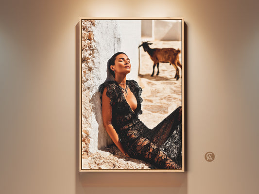 Mediterranean Aesthetic Fashion Photography. A woman in a black lace dress is basking in the sun. A goat stands in the background. The artwork captures a travel-inspired scene. It brings an eclectic touch to any space. This print is perfect for fashion lovers and unique home decor. It enhances contemporary and eclectic interiors.