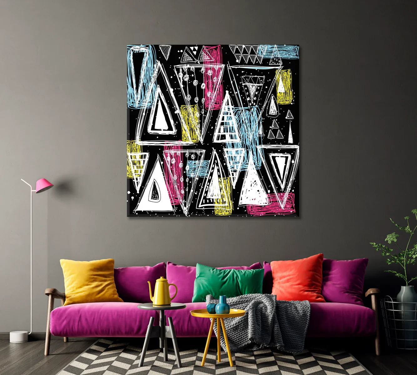 Graphic abstract canvas on a charcoal wall above a colorful sofa