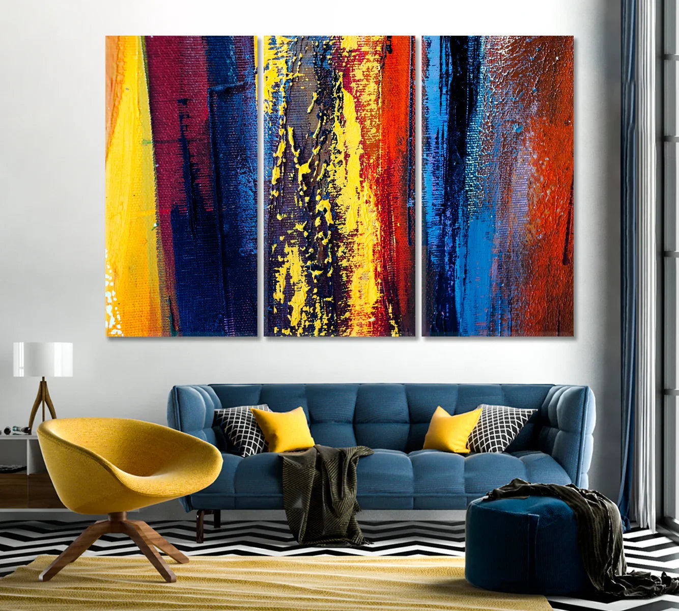 Triptych of bold blue, yellow and red abstract brushstrokes above a modern blue sofa
