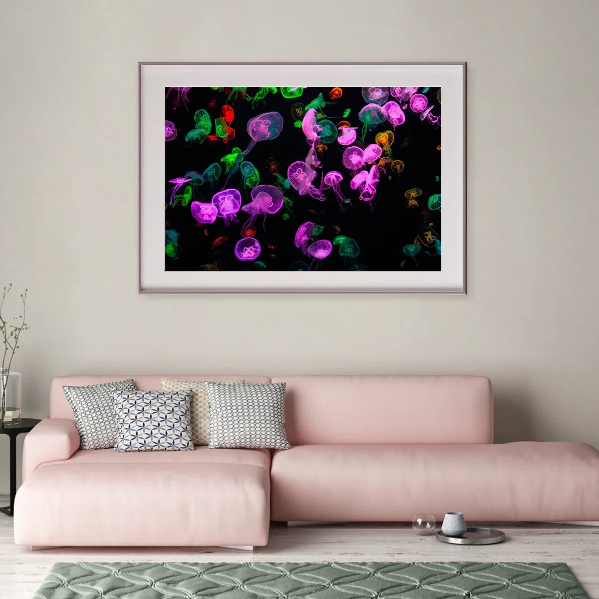 Multicolor jellyfish poster in a white frame over a blush sofa