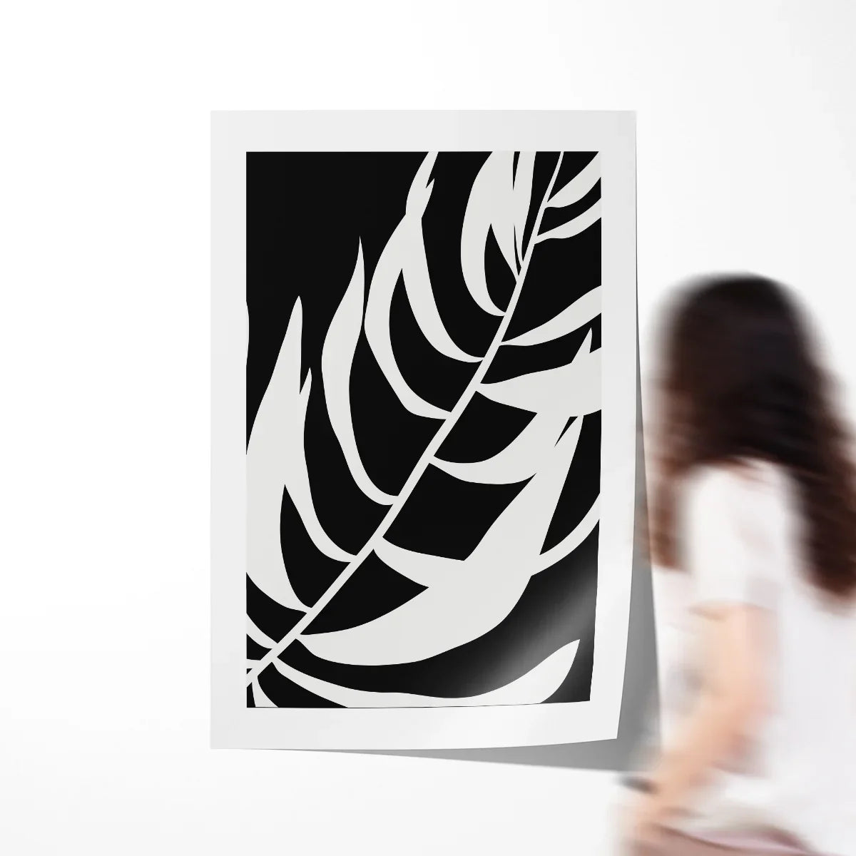 Abstract leaf poster in warm neutrals framed above a sofa, showing modern geometric leaves with soft curves.